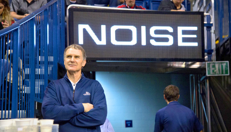 Mike Roth in front of a sign that reads, 'Noise'