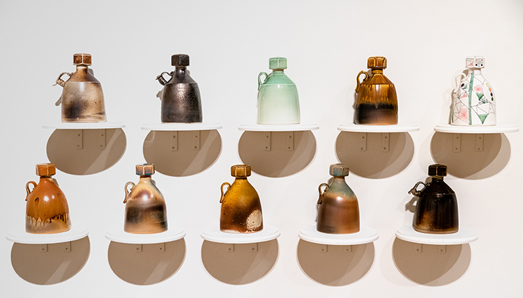 Two rows of five growlers with screw top lids, cast porcelain by Mat Rude from the GU Art Department Faculty Exhibition