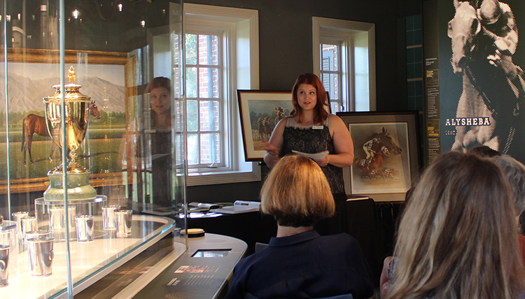 Jenni presents to a gathering at a museum exhibit