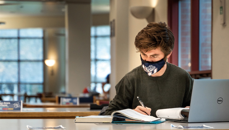 student studies with mask on