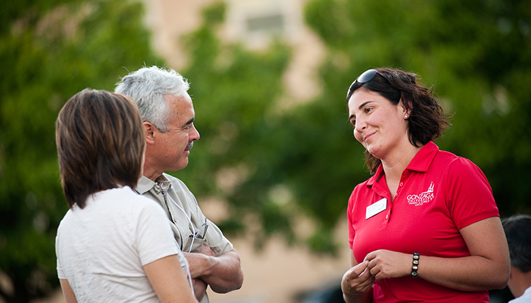 woman talks with parents on campus
