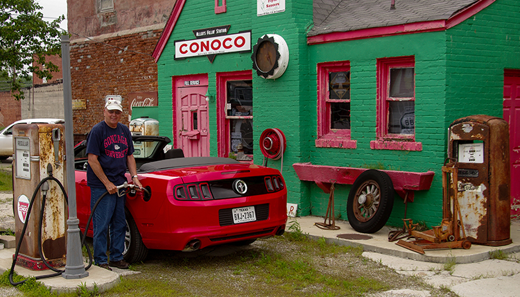 old conoco station on Route 66 with Gonzaga alum pumping gas in Mustang convertible