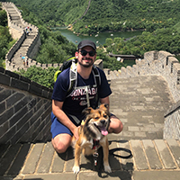 Peter and his dog pose on the Great Wall of China.