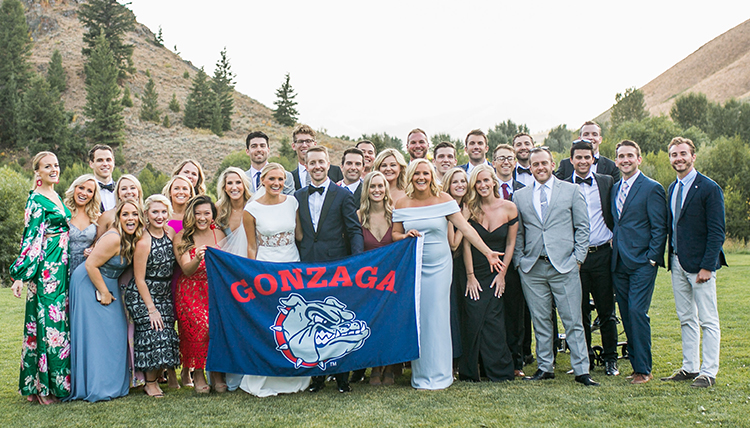 large wedding party outdoors with GU flag