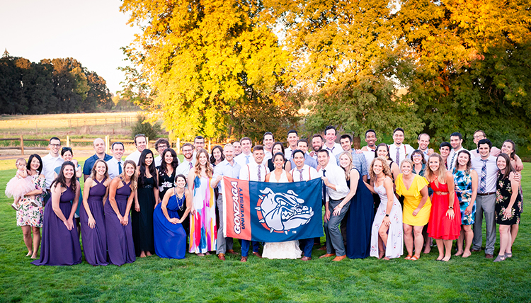 large wedding party outdoors with people holding bulldog flag