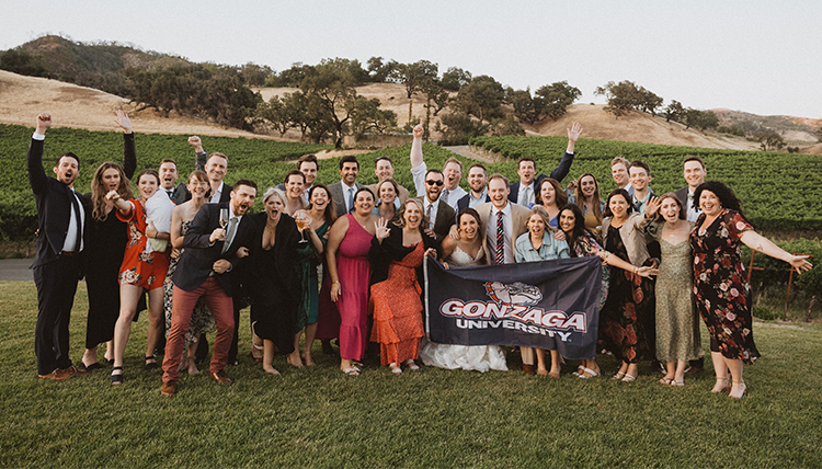 large wedding party outdoors with GU flag