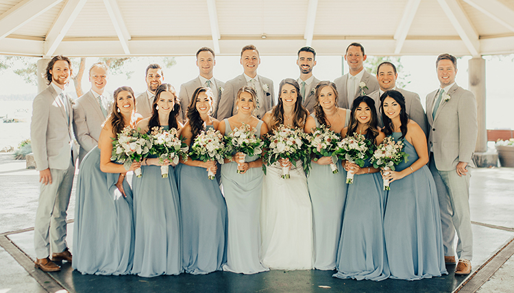 large wedding party with women in blue and men in gray