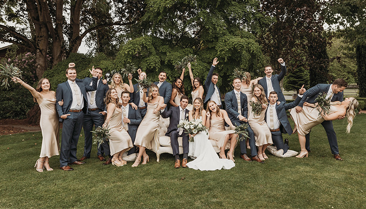 large wedding party in fun poses outdoors
