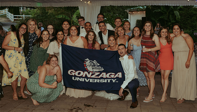 group of friends and couple holding gonzaga flag