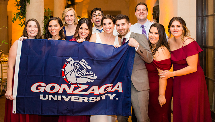 group of Zags around couple with Gonzaga flag