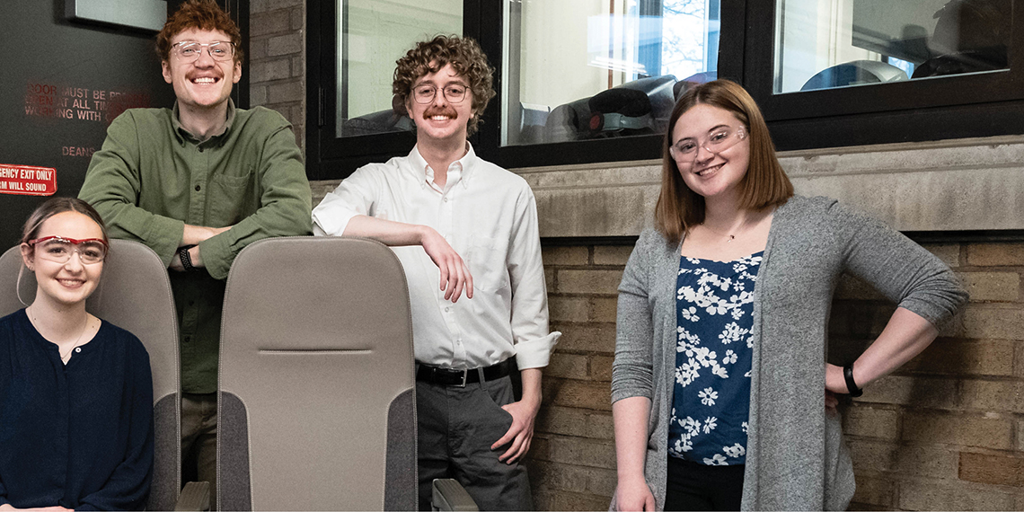 four students around 2 aircraft seats