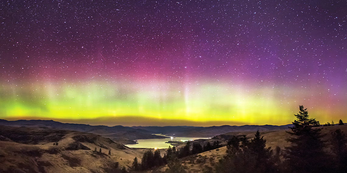 The Aurora Borealis, which symbolizes the spiritual themes of discernment, hovers over the Columbia River and Keller Ferry in Eastern Washington.