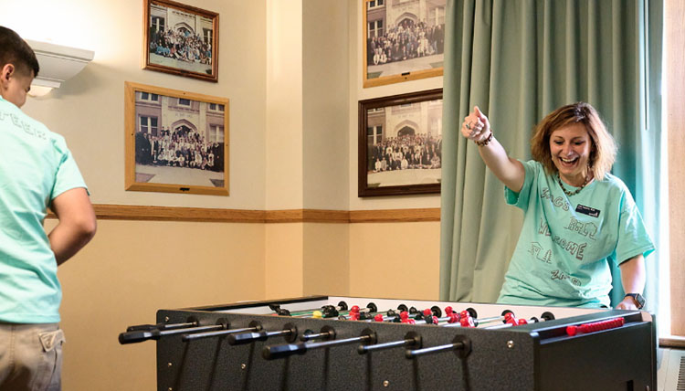 President Passerini smiling while playing foosball with a 51Թ