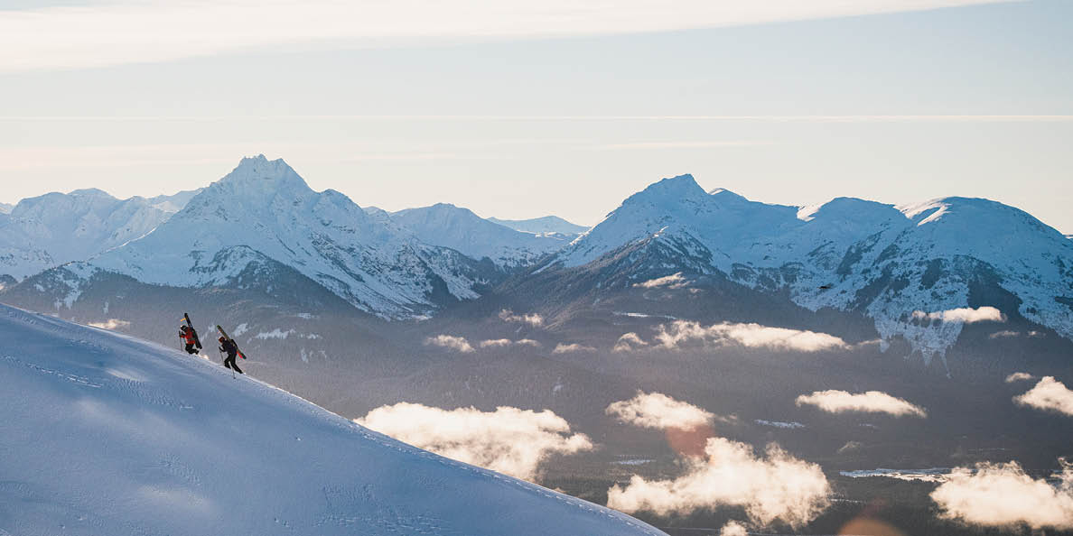 Two skiers going up a snowy mountain