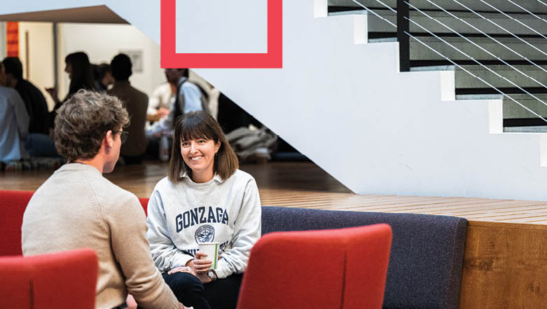 GU student and Microsoft alumni engaged in conversation on couches