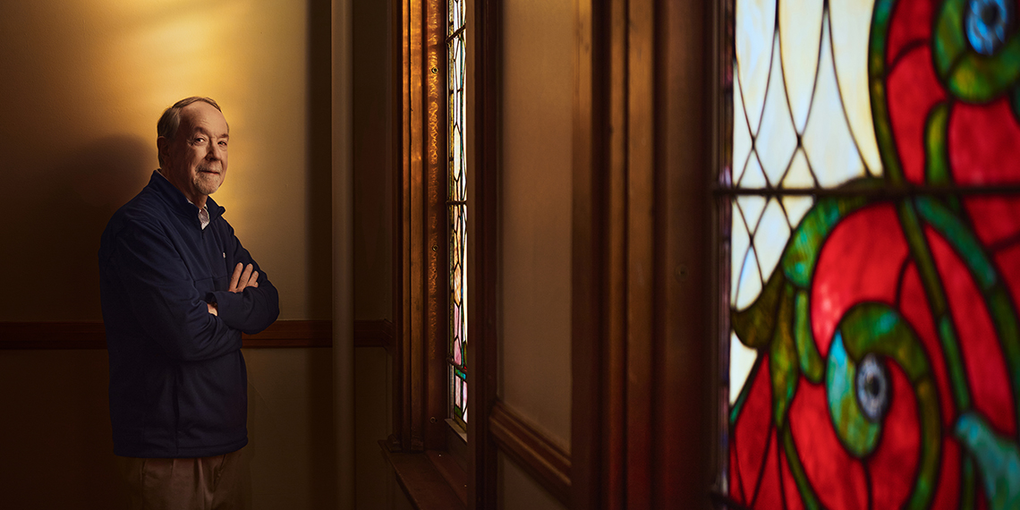Chuck Murphy posed near stained glass windows