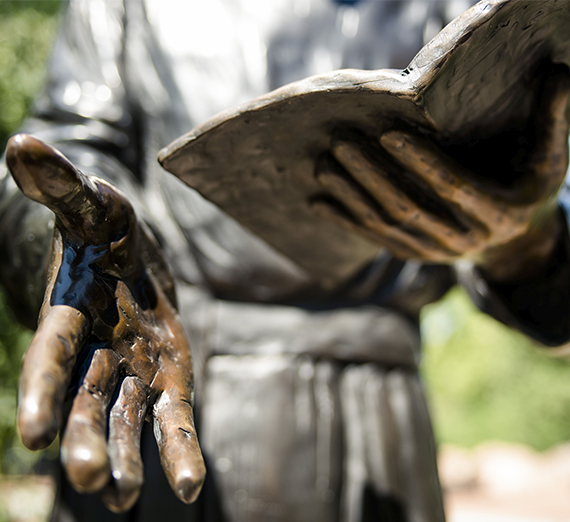 A statue's hands and bible at Regis University. 