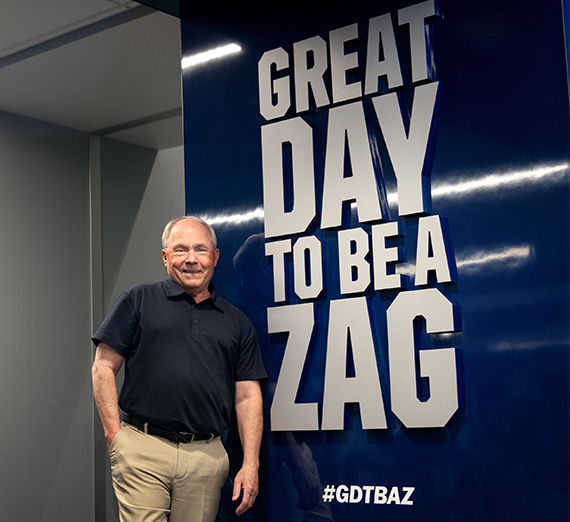 dale in front of sign reading great day to be a zag