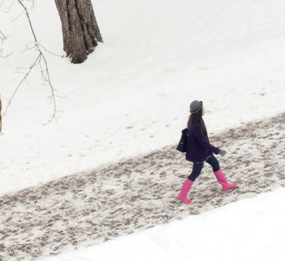girl walking on snowy path marked by footprints
