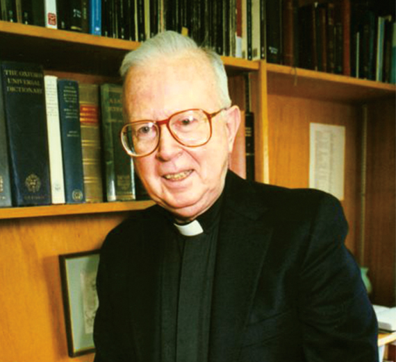 priest with bookshelf in background 
