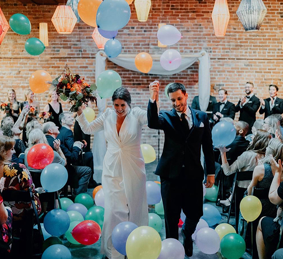 man and woman celebrate amid balloons