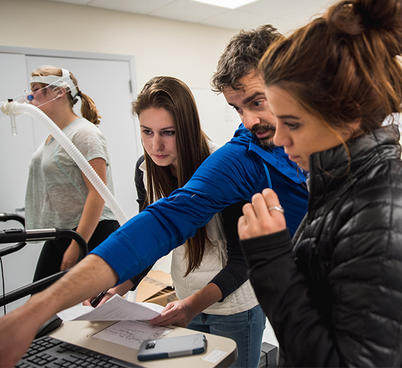 A professor works with a student in a human physiology class. 