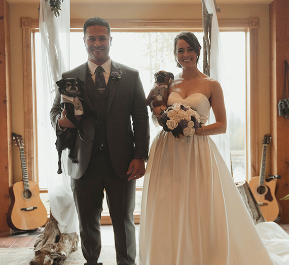 wedding man and woman holding their dogs 