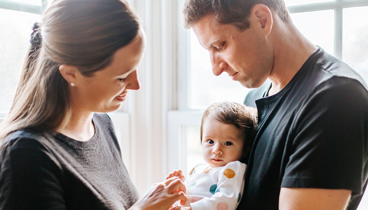 Two parents hold their baby