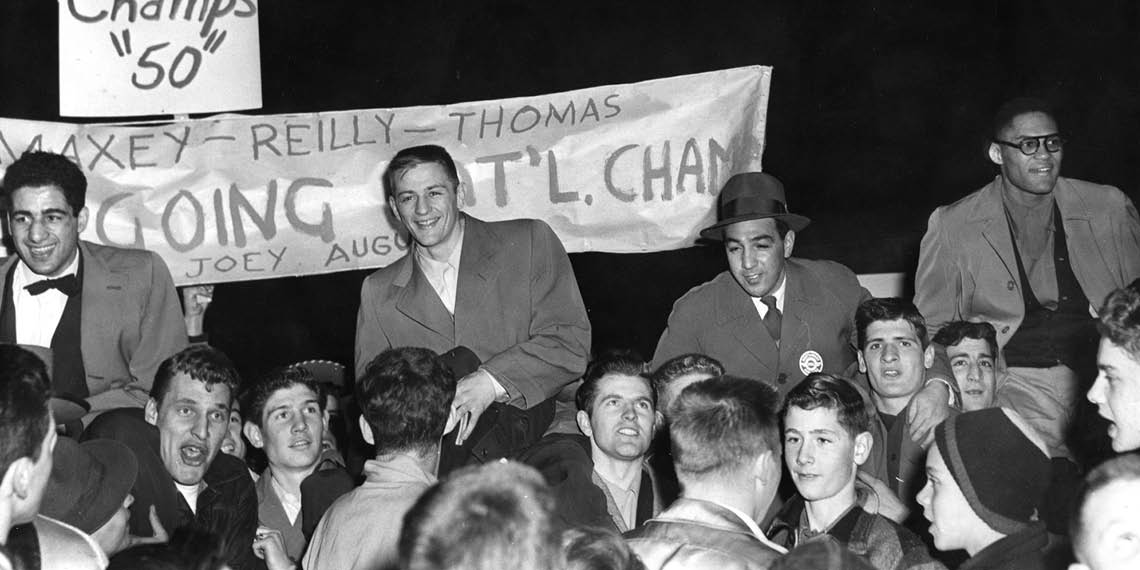 Eli Thomas, Jim Reilly, Coach Joey August, and Carl Maxey celebrate in Spokane as fans lift them after the 1950 boxing championship win.