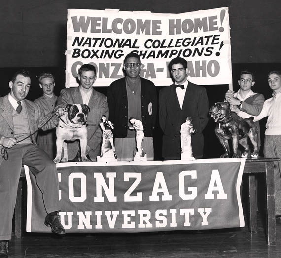 Gonzaga’s 1950 boxing champions are welcomed home under a banner celebrating their national title.