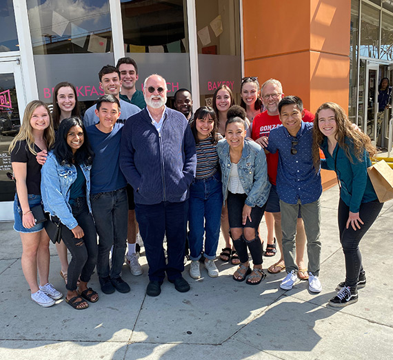 Father Greg Boyle sits in his picture and painting filled office.