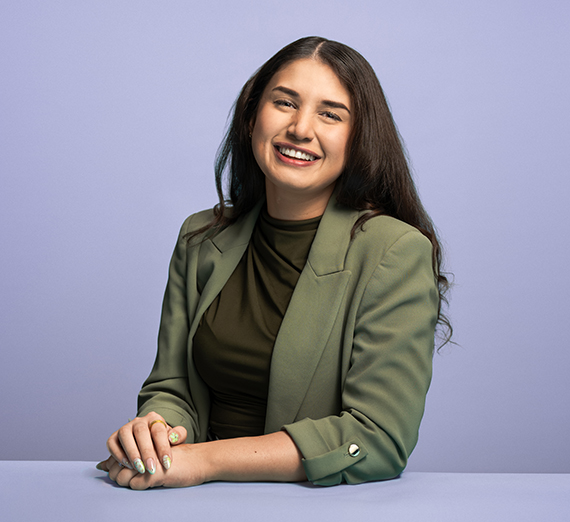 Ava Sharifi (’25 J.D.) smiling in a green blazer.