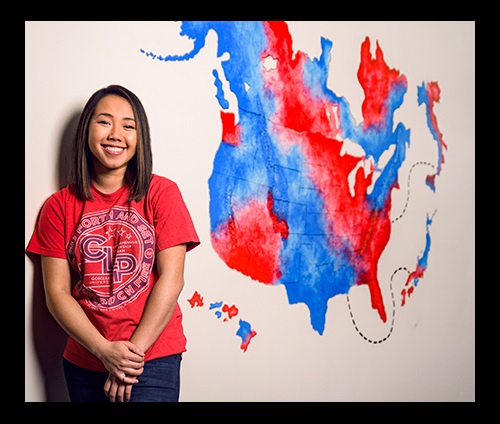 Cat Truong (’14) in front of the mural she created in Gonzaga's advancement office. (Photo by Zack Berlat)