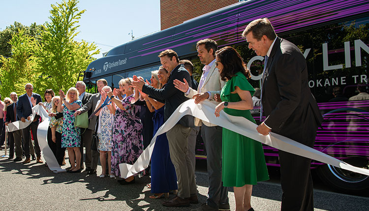 Dignitaries in a line cutting a giant white ribbon