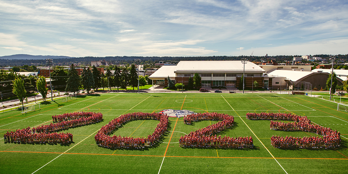 Students spelling out the year 2023 on the grass north of Hemmingson