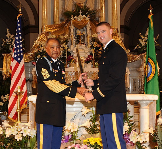 Command Sergeant Major Thomas E. Williams, left, present an award to Shane Barnes on St. Aloysius altar