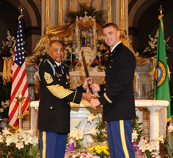 Command Sergeant Major Thomas E. Williams, left, present an award to Shane Barnes on St. Aloysius altar 