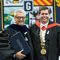 two men dressed in commencement robes