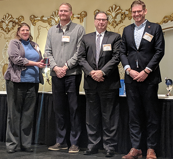 Julie Oliver, director of the Spokane Regional Clean Air Agency, presents the Clean Air Award to (from left) GU administrators Tomson Spink,  Jim Angelosante, and Jim Simon.