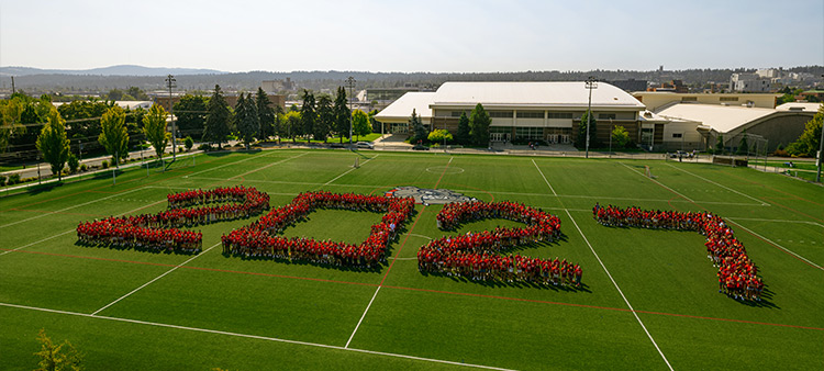 Students in red t-shirts line up to form a 2027