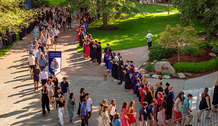 Professors in regalia line a path into St. Aloysius church