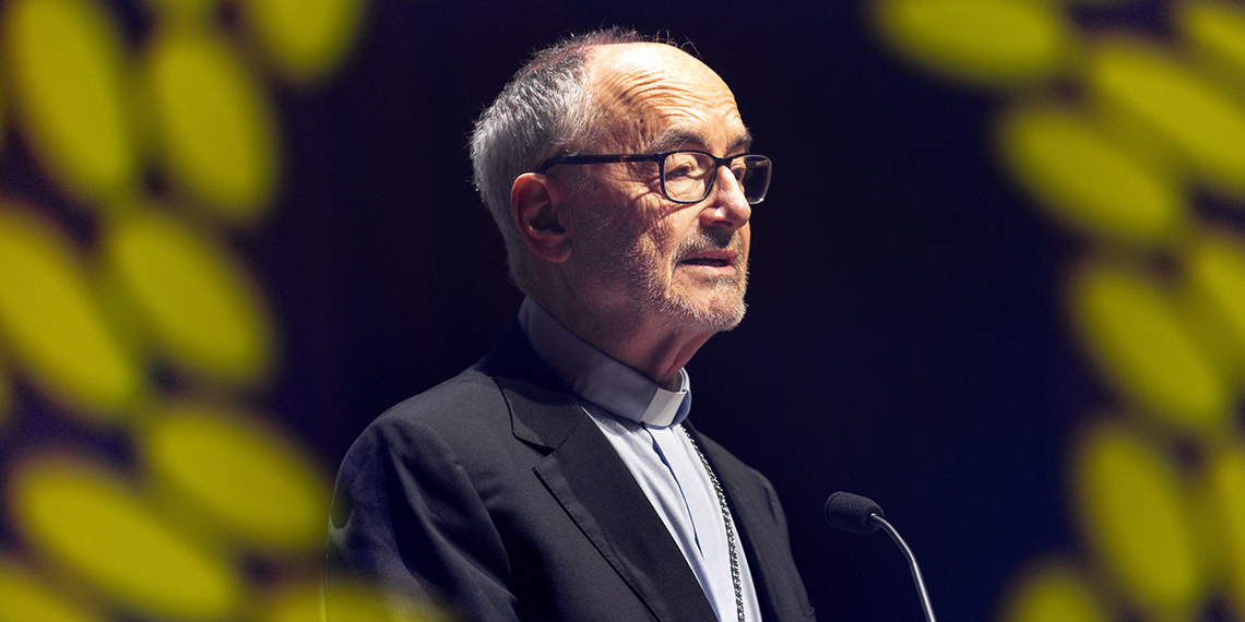 Cardinal Michael Czerny speaking at a microphone