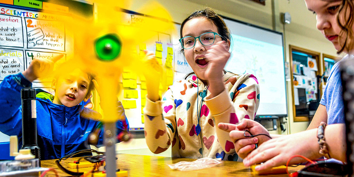 Elementary students working with climate kits in the classroom.