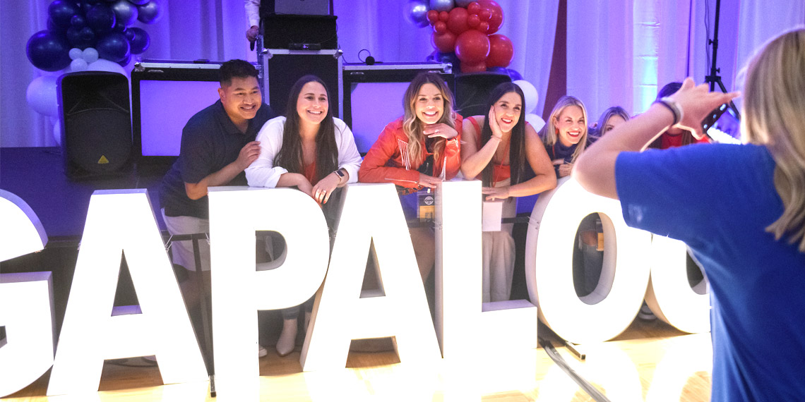 A group of alumni get their photo taken in front of the light-up Zagapalooza sign at Gonzaga University's 2022 Zagapalooza all-class reunion.