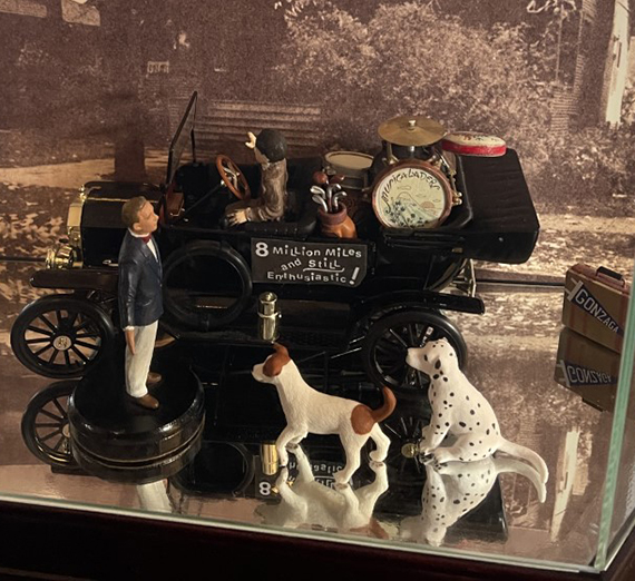 Diorama of Bing Crosby singing to two dogs next to a model car 
