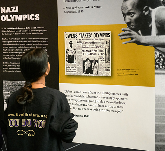 A high school student looks at a display of Jesse Owens from the Americans and the Holocaust exhibit 
