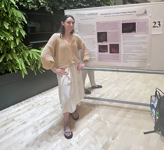 Rhys Heenan stands in front of a whiteboard covered with information from her research into effects of menstruation on maximal exercise performance