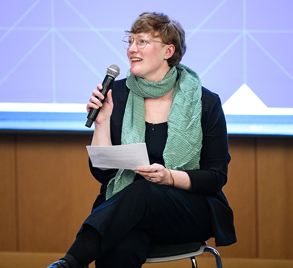 Kate Bitz of the Western States Center sits holding a microphone