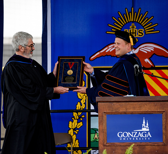 Chief Justice McGrath receiving law medal on stage 