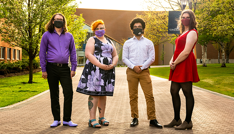 four individuals stand outdoors